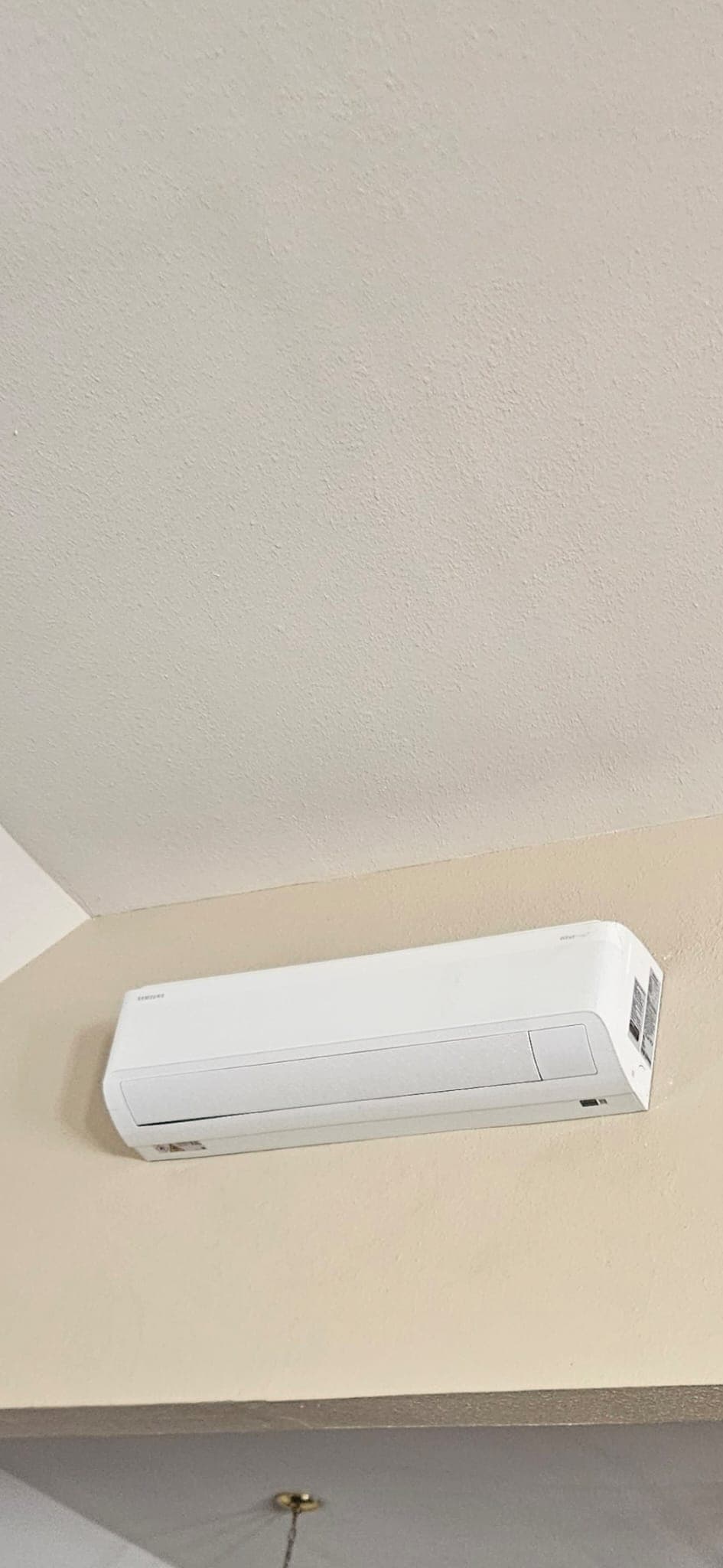 White ductless mini-split indoor unit mounted high on an interior wall