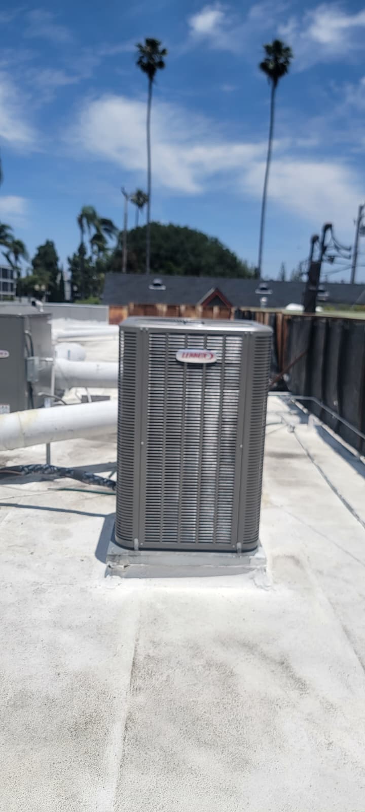 Lennox condensing unit mounted on a flat rooftop platform