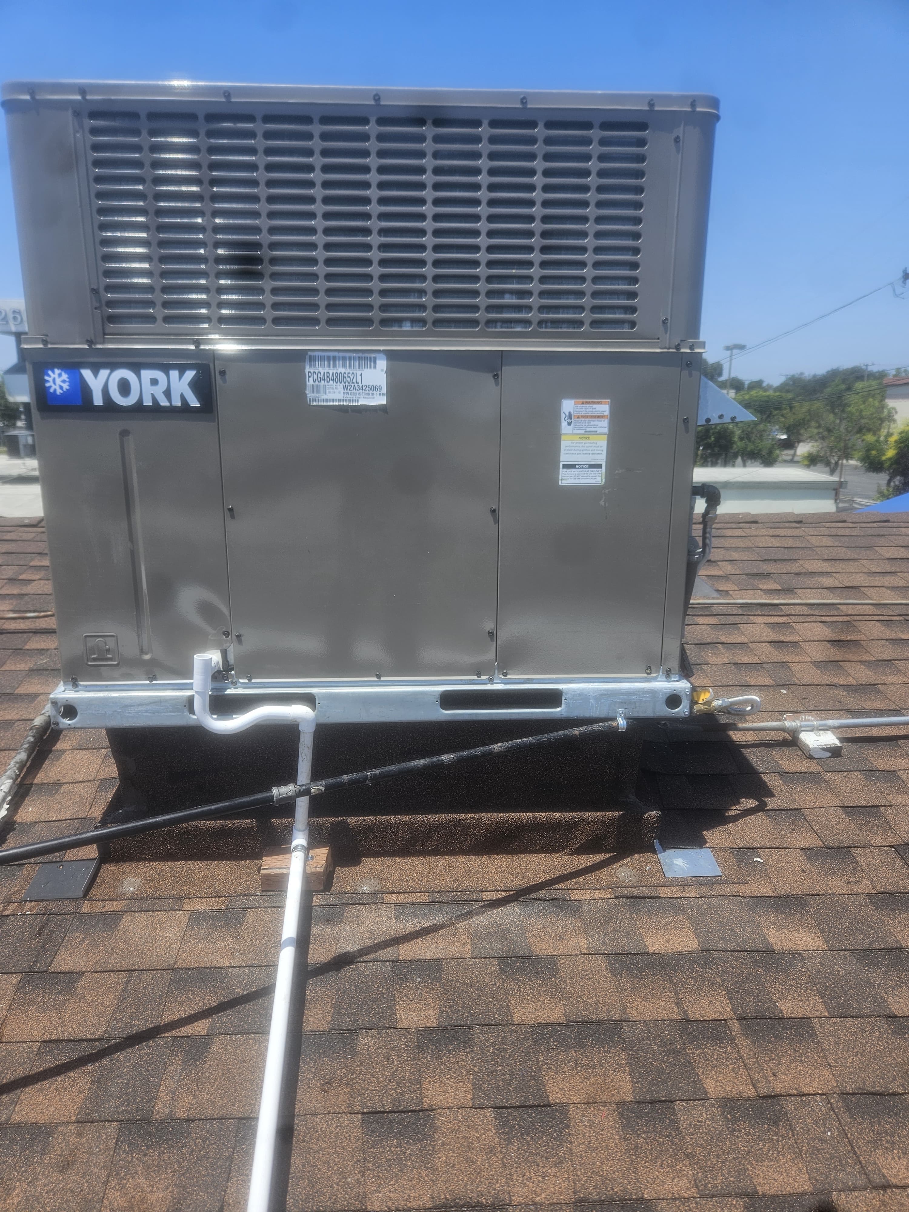 Unidad paquete York instalada sobre un techo inclinado de teja asfáltica